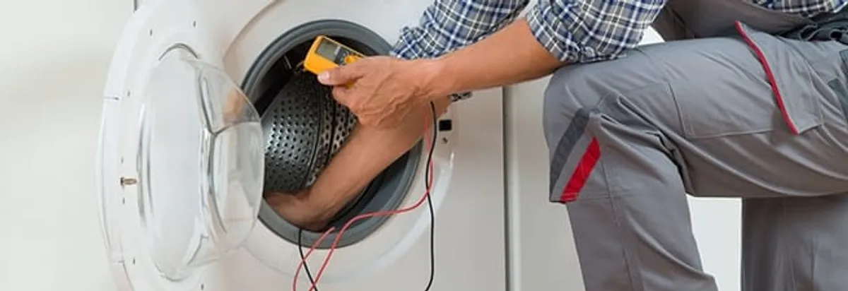 Dryer repair technician inspecting and repairing a clothes dryer in Columbus, OH