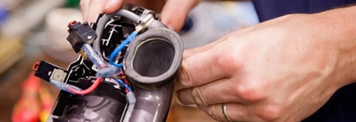 Vacuum repair technician reconnecting wiring and components in Columbus, OH